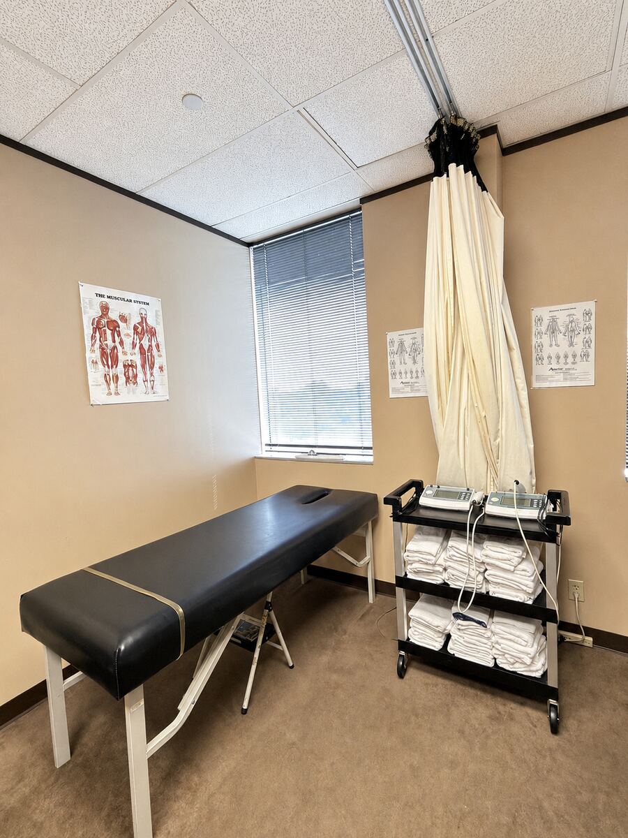 Exam room with treatment table and anatomy charts